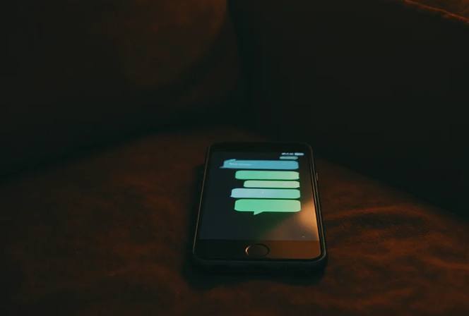 Smartphone op een bank met een geopend chatgesprek in beeld